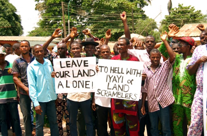 En protesta contra Okomu Oil Palm Oil en Nigeria, algunos afectados sostienen pancartas con leyendas como "Dejen nuestras tierras en paz" y otras