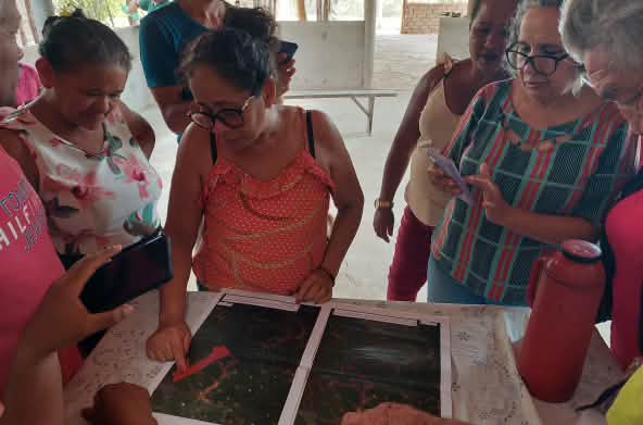 Una representante de la Comisión Pastoral de la Tierra (CPT), presenta un mapa con los límites de la tierra ancestral de la comunidad de Timbiras