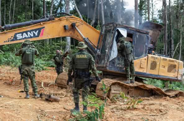 Intervención de la agencia medioambiental IBAMA. Un grupo de hombres con trajes militares intervienen una draga amarilla en la selva tropical