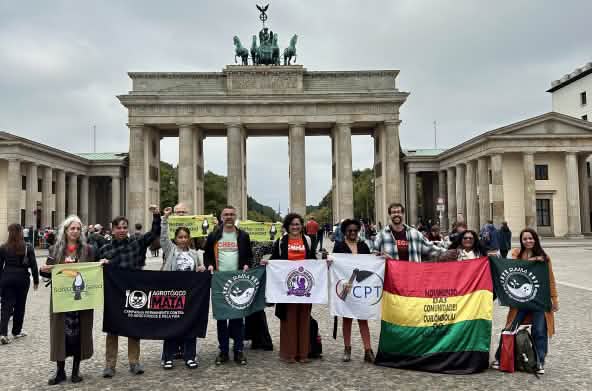 Grupo de personas posa con pancartas delante de la puerta de Brandemburgo en Berlin