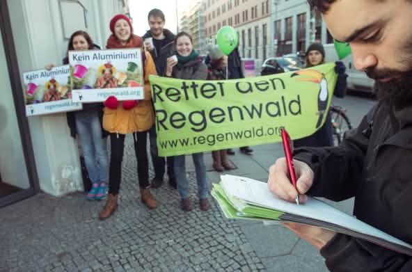 Activistas de Salva la Selva/Rettet den Regenwald con pancartas