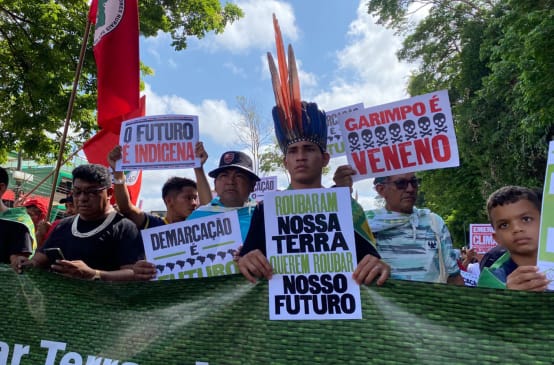 Indígenas marchando sostienen pancartas en las que se lee en portugués: Robaron nuestra tierra, quieren robar nuestro futuro” y “El futuro es indígena”