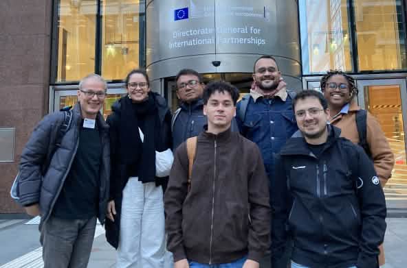 Foto de grupo de 7 personas frente a la entrada de un edificio de la Comisión de la UE en Bruselas