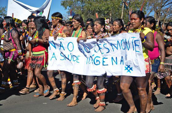 Mujeres indígenas de brasil protestan contra la destrucción de sus territorios con una pancarta en la que dice “Nao ao desmonte” contra la deforestación de la selva tropical