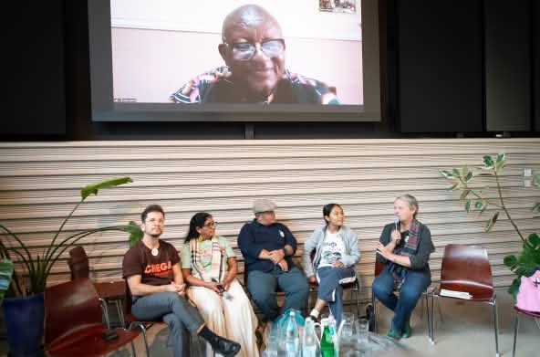 Seis personas protagonizan una conversación sobre un escenario, una de ellas desde una pantalla