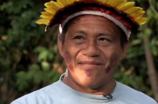 Retrato en primer plano del líder indígena Sarapo Ka’apor, con un tocado de plumas