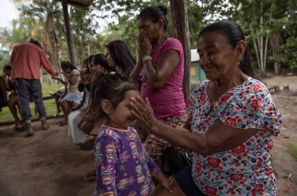 Una niña pequeña huele los aceites esenciales de las manos de una mujer mayor