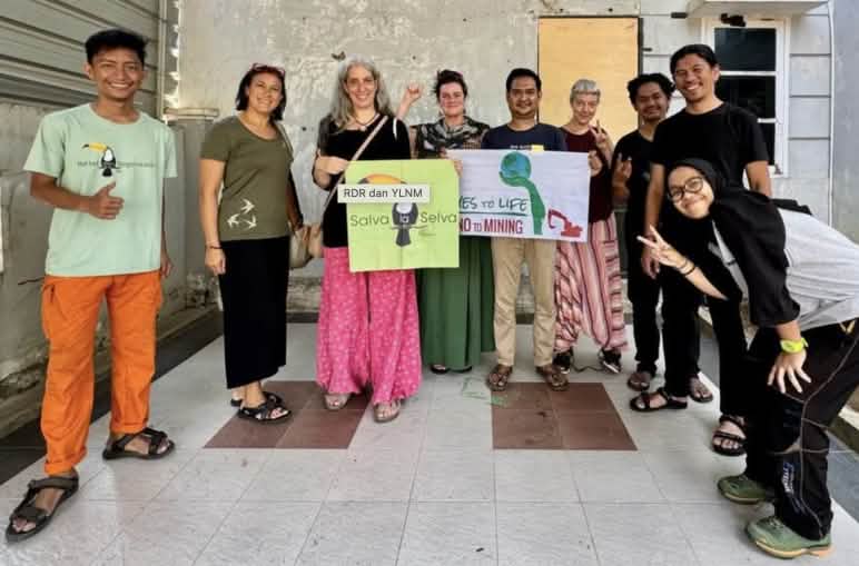 Nueve activistas con las banderas de Salva la Selva y Yes to Life No to Mining en la oficina de Walhi Sulawesi