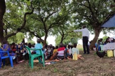 Conversación al aire libre en una comunidad, sobre el peligro de la explotación petrolífera