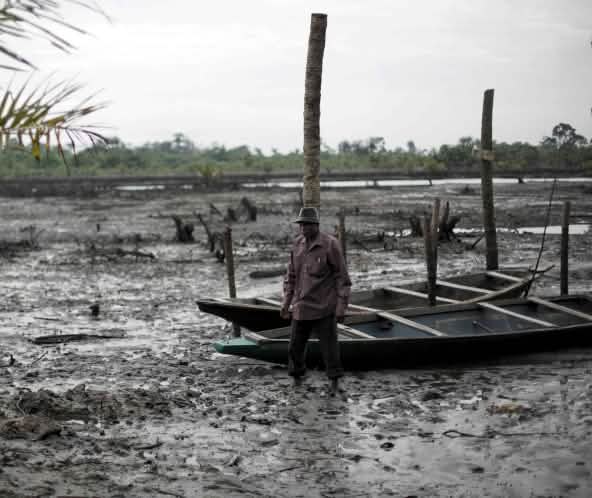 Un hombre cerca de un río contaminado por petróleo en el delta del Níger.
