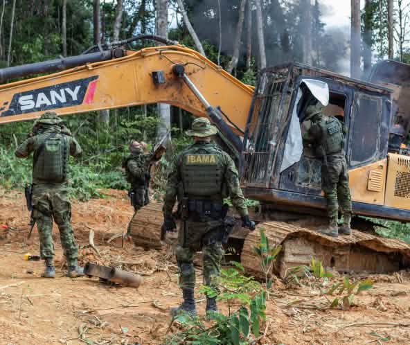 Intervención de la agencia medioambiental IBAMA. Un grupo de hombres con trajes militares intervienen una draga amarilla en la selva tropical
