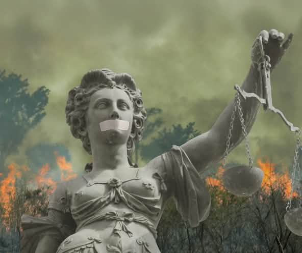 Fotomontaje: Una estatua de la Justicia con la boca tapada ante la selva tropical en llamas