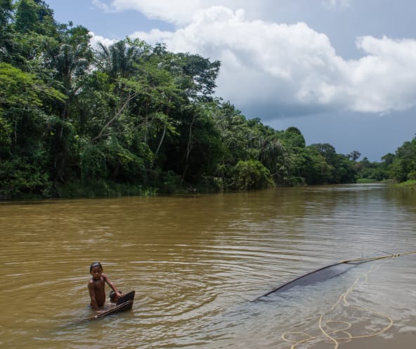 Niño se baña en el río Caquetá, en Colombia, del cual preocupa la contaminación con mercurio