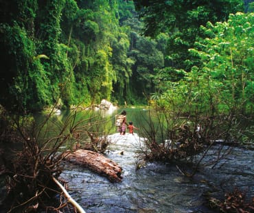 Dos personas cruzan el río Tanabang