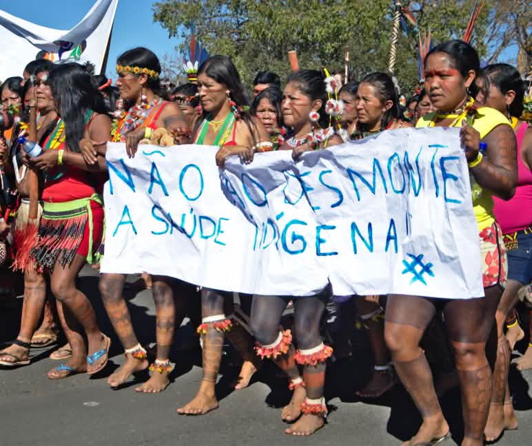 Mujeres indígenas de brasil protestan contra la destrucción de sus territorios con una pancarta en la que dice “Nao ao desmonte” contra la deforestación de la selva tropical
