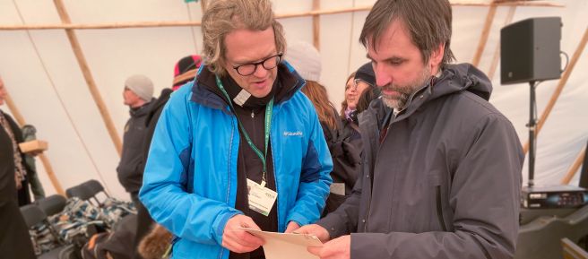 El Ministro de Medio Ambiente de Canadá, Steven Guilbeault (derecha), acepta una impresión de la petición de Salva la Selva relativa a la biodiversidad, con más de 65.000 firmas