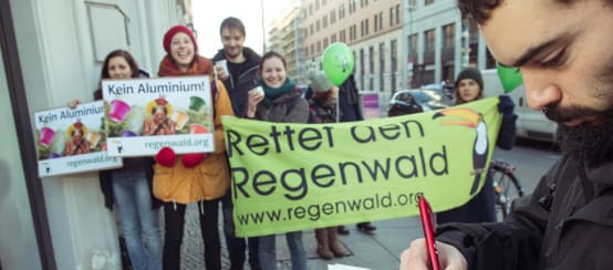 Activistas de Salva la Selva/Rettet den Regenwald con pancartas