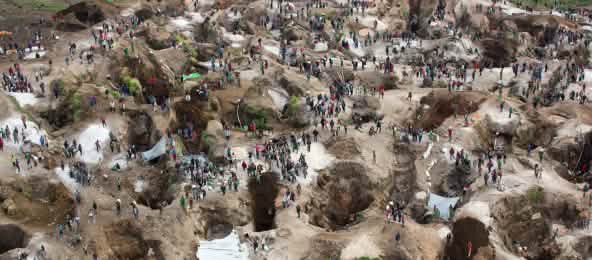 El coltán está en el centro de violentos conflictos que sacuden la República Democrática del Congo (© MONUSCO/Sylvain Liechti/CC BY-SA 2.0) Vista aérea de una mina, con agujeros profundos, parcialmente llenos de agua, entre los cuales se encuentran numerosas personas