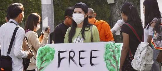Una joven activista en Phnom Penh pide la liberación de los activistas (© MNC) Joven mujer con un gran cartel en el que se lee «¡Liberad a los activistas de Mother Nature!».