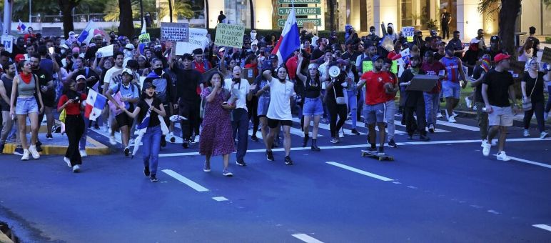 Un gran grupo de personas protestan en las calles con pancartas y banderas de Panamá en contra de la minería en 2023