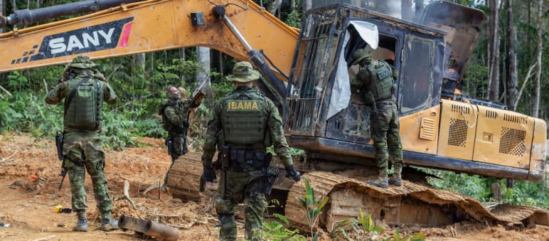Intervención de la agencia medioambiental IBAMA. Un grupo de hombres con trajes militares intervienen una draga amarilla en la selva tropical