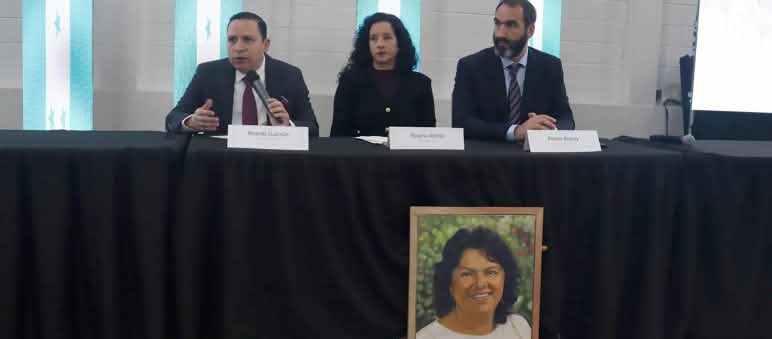 Mesa de los tres integrantes de GIEI, tras un retrato de Berta Cáceres