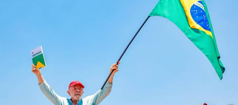 El presidente Brasileño Lula da Silva con una bandera en la mano izquierda y la Constitución en la mano derecha