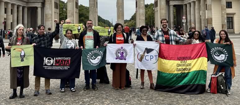 Grupo de personas posa con pancartas delante de la puerta de Brandemburgo en Berlin