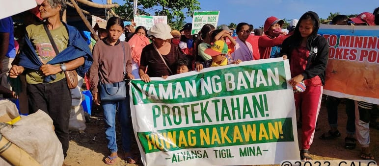 "¡Protejan la riqueza del pueblo! ¡No al saqueo! Alianza contra la Minería" está escrito en la pancarta Un grupo de personas sostiene una pancarta en la que se lee (traducido): "¡Protejan la riqueza del pueblo! ¡No al saqueo! Alianza contra la Minería"