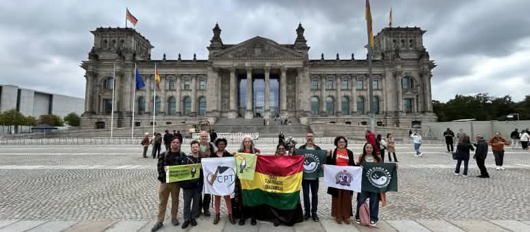Grupo de personas con pancartas delante de la sede del parlamento alemán