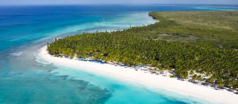 La isla tropical de Saona, rodeada de arrecifes de coral, es parte del Parque Nacional Cotubanamá Vista aérea de la Isla Saona en la República Dominicana con sus cocoteros y el turquesa del Mar Caribe