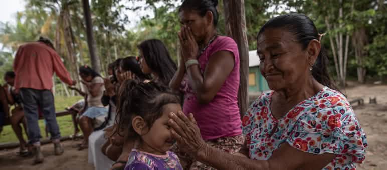Una niña pequeña huele los aceites esenciales de las manos de una mujer mayor