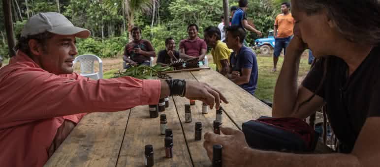 Dos hombres frente a frente observan las botellitas que se utilizan para almacenar los aceites esenciales del proyecto