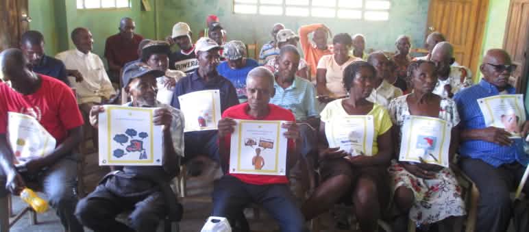 Grupo comunitario del noreste de Haití con las cartas del juego de 50 preguntas sobre la minería