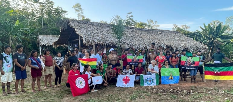 Grupo de personas en el territorio indígena Ka'apor posa con banderas