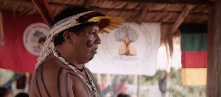 Líder indígena Ithau Ka'apor, de perfil, hablando en una reunión