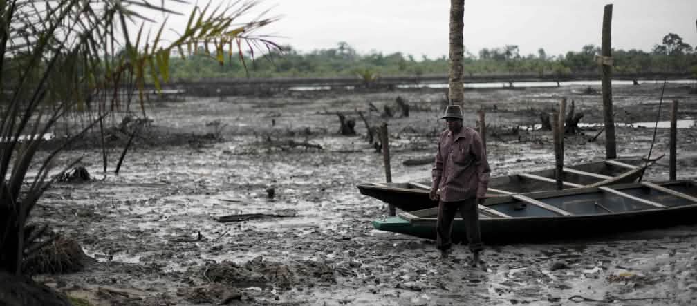 Un hombre cerca de un río contaminado por petróleo en el delta del Níger.
