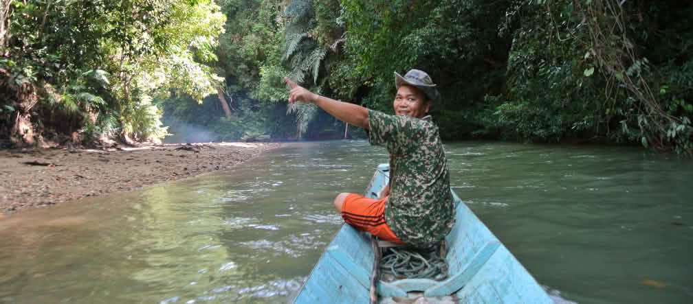 El pueblo indígena Iban quiere proteger a toda costa las selvas y los ríos de Sarawak, Borneo. Un hombre señala la selva tropical en Sarawak, Borneo, desde un bote