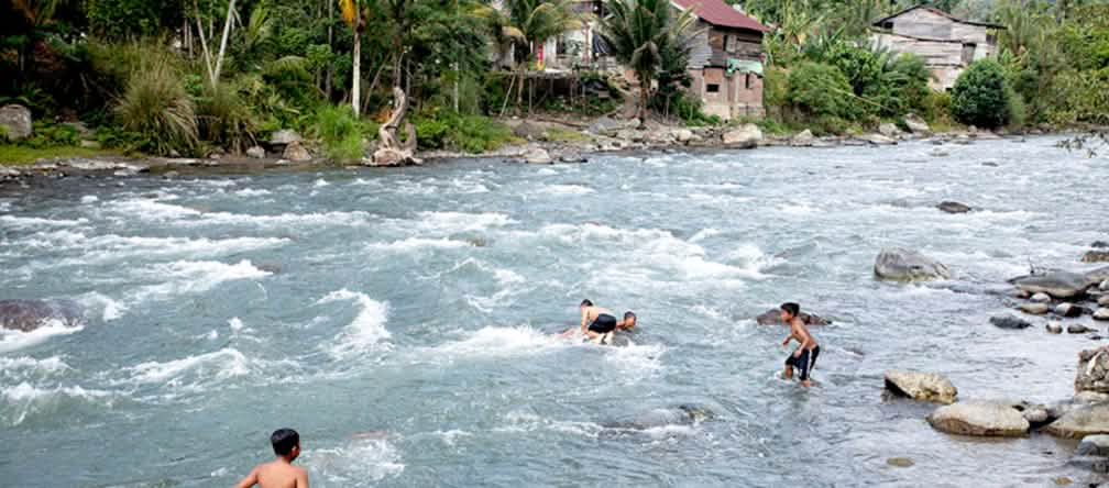 Niños bañándose y jugando en el río