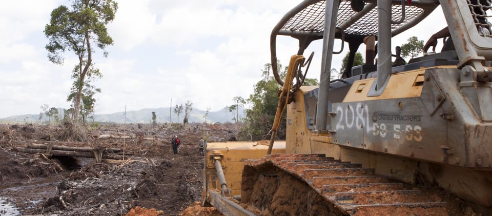 Bulldozers fuera de la selva Excavadora en primer plano destruyendo la selva tropical