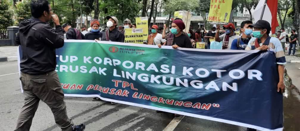 Fotógrafo y manifestantes con una pancarta verde