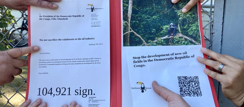 Manos unidas sobre la petición contra la extracción petrolera en defensa de las selvas de la RD Congo, frente a la embajada de ese país, en Berlín, el 4 de agosto de 2022