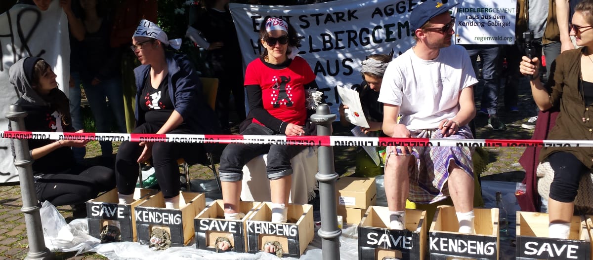 Activistas cementan sus pies en señal de protesta durante la junta de accionistas de HeidelbergCement