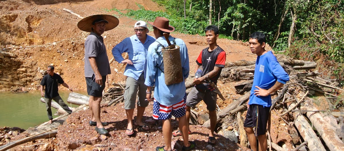 Indígenas ante un camino de tierra construido ilegalmente por madereros en Sarawak para extraer madera ilegal
