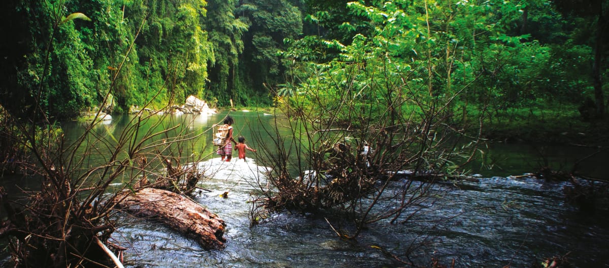 Dos personas cruzan el río Tanabang