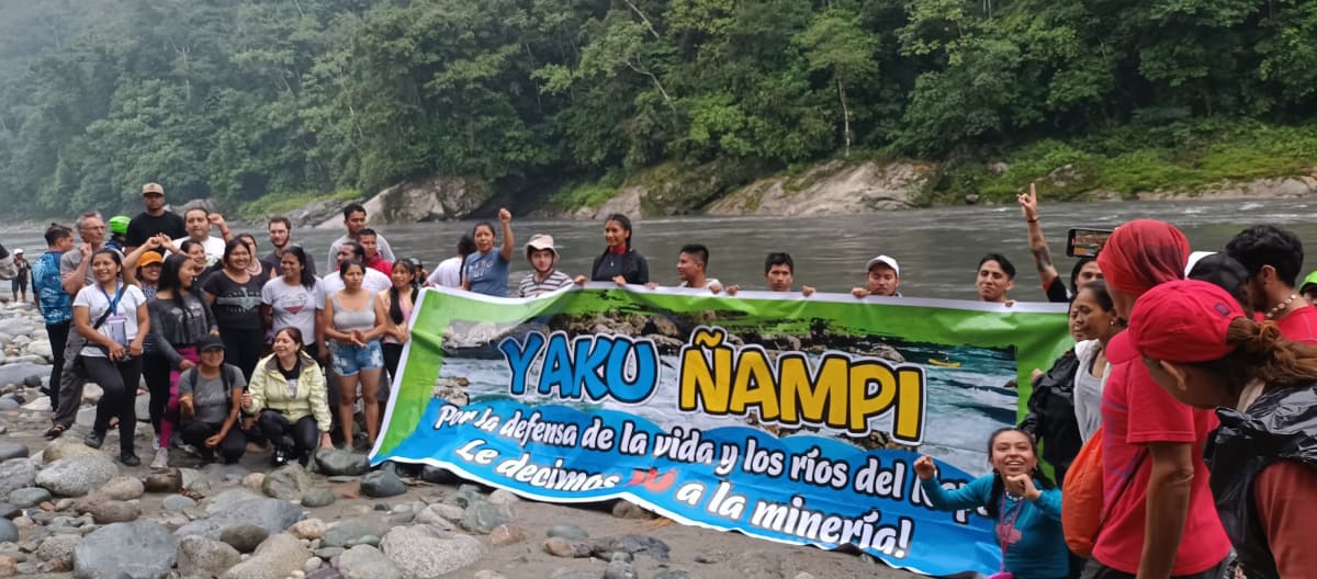 Protesta en contra de la minería de oro: un grupo de personas con una pancarta que dice “Por la defensa de la vida y los ríos del Napo, de decimos ¡No a la Minería!