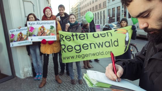 Activistas de Salva la Selva/Rettet den Regenwald con pancartas