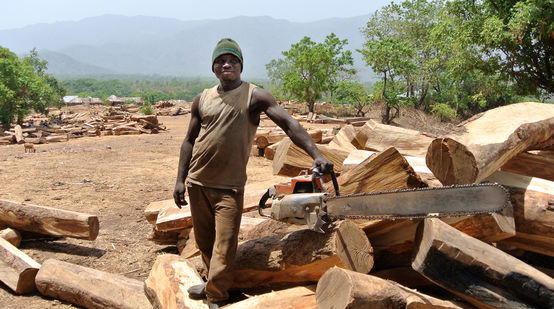 Maderero con motosierra en un almacén de madera al aire libre en Nigeria
