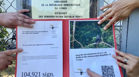 Manos unidas sobre la petición contra la extracción petrolera en defensa de las selvas de la RD Congo, frente a la embajada de ese país, en Berlín, el 4 de agosto de 2022