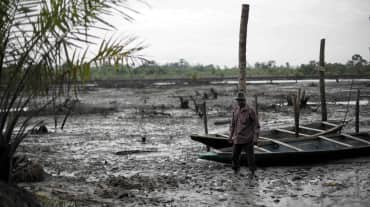 Un hombre cerca de un río contaminado por petróleo en el delta del Níger.